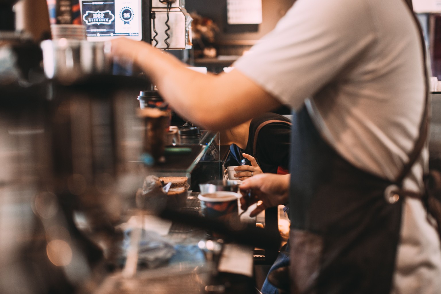 Coffee shop barista preparing drinks, representing the coffee shop social media case study